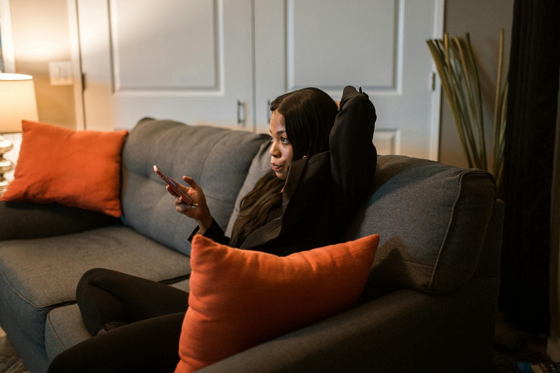 woman in black blazer and black pants sitting on a couch