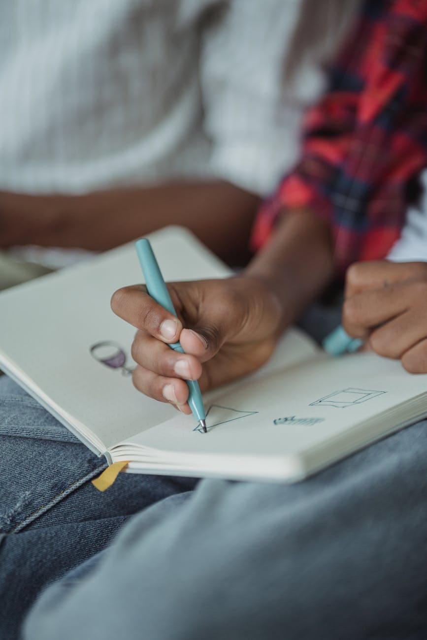close up of a person drawing in a notebook